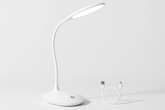 White LED desk lamp with USB cable on a light gray background